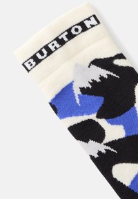 Pletené ponožky s bielou manžetou a logom "BURTON", s modrým, čiernym a bielym horským vzorom, navrhnuté pre teplo a pohodlie.