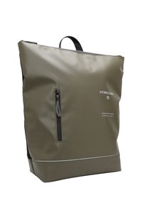 Mochila verde oliva hecha de material impermeable, presenta un bolsillo frontal con cremallera, acentos negros y una forma rectangular con un asa superior.