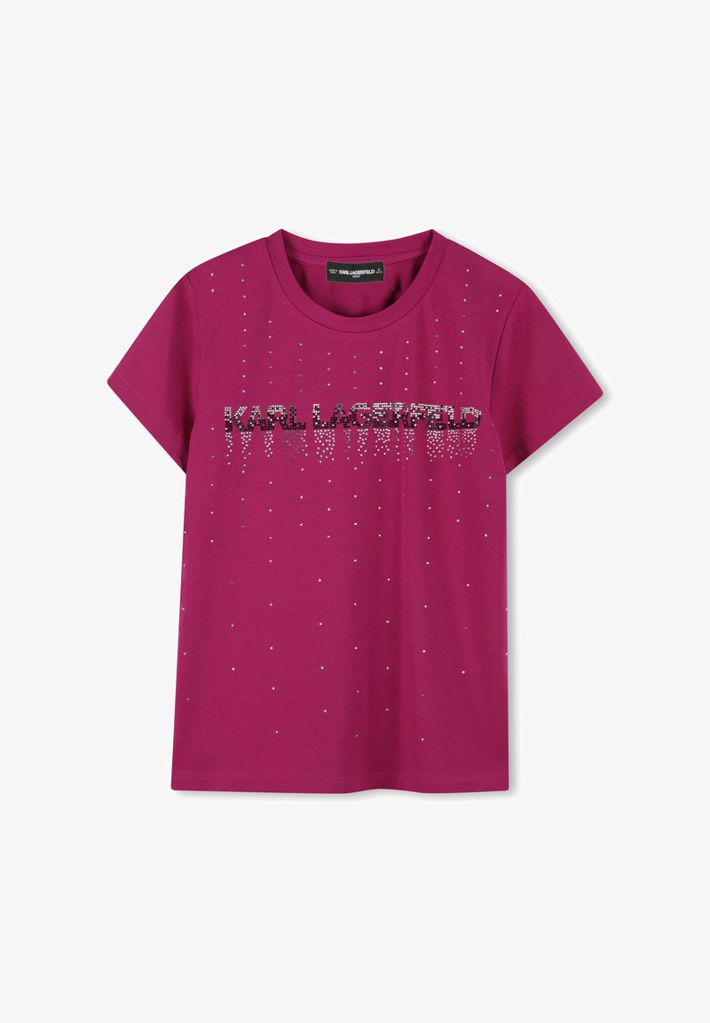 T-shirt en coton fuchsia avec des manches courtes, un col rond et un logo orné de strass, disposé verticalement sur le devant.