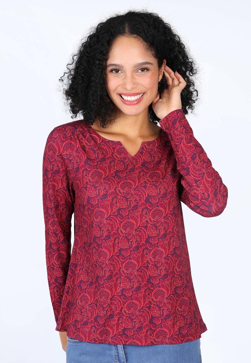 Rote Bluse mit langen Ärmeln und V-Ausschnitt, die auf weichem Stoff detaillierte Stickmuster zeigt und eine lässige Passform hat.