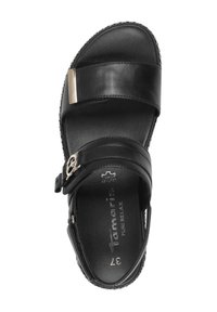 Zwarte leren sandaal met verstelbare band en metallic accent, met een gevoerd voetbed en contrasterende stikdetails.
