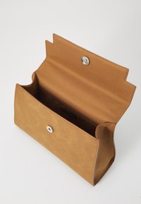 Tan syntetisk taske med tryklås, åben for at vise et rummeligt interiør. Har glat tekstur og afrundede kanter, minimalistisk design.