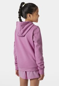 Sudadera morada con una textura suave, capucha ajustable y mangas largas. Combinada con una falda rosa a juego, ambos artículos son casuales y deportivos.