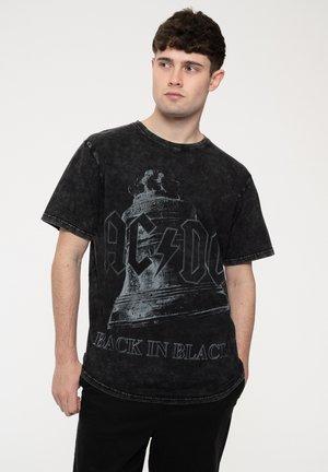 Black cotton T-shirt with a faded look, featuring a bell graphic and "AC/DC BACK IN BLACK" text in bold, distressed font. Short sleeves.