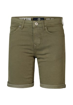 Boy wearing pale yellow polo shirt, olive rolled-up shorts, white socks, and white sneakers standing against plain background.