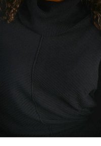Maglione a collo alto nero con design a coste texturizzato, cuciture diagonali e un tessuto morbido e flessibile.