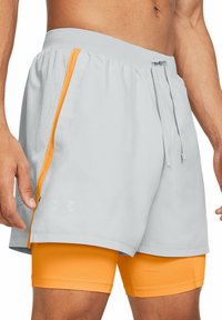 Grå atletiske shorts med orange detaljer, elastisk talje og snor. Har mesh-sidepaneler og et tætsiddende orange for underneden.