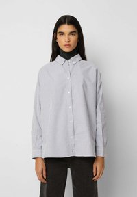 Stripet skjorte i lys blå og hvid bomuld, med en afslappet pasform, lange ærmer og en klassisk krave. Struktureret stofdetalje.