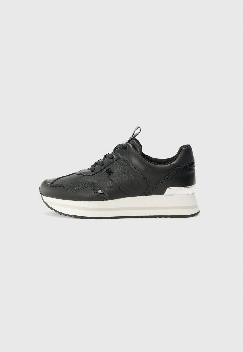 Black leather sneaker with a smooth texture, featuring a round toe, front lacing, and a white and silver accent on the sole.
