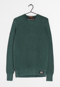 Pull en tricot vert avec un motif texturé, col rond, poignets et ourlet côtelés, comportant une étiquette sur le bas à gauche.