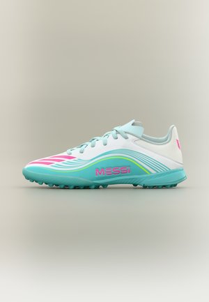 Zapato de fútbol con parte superior blanca, detalles en verde menta, logo rosa y franjas decorativas. Cuenta con una suela texturizada para mayor agarre.