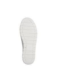 Semelle de chaussure blanche avec des rainures horizontales et diagonales, et un petit logo circulaire au centre de la zone du talon.