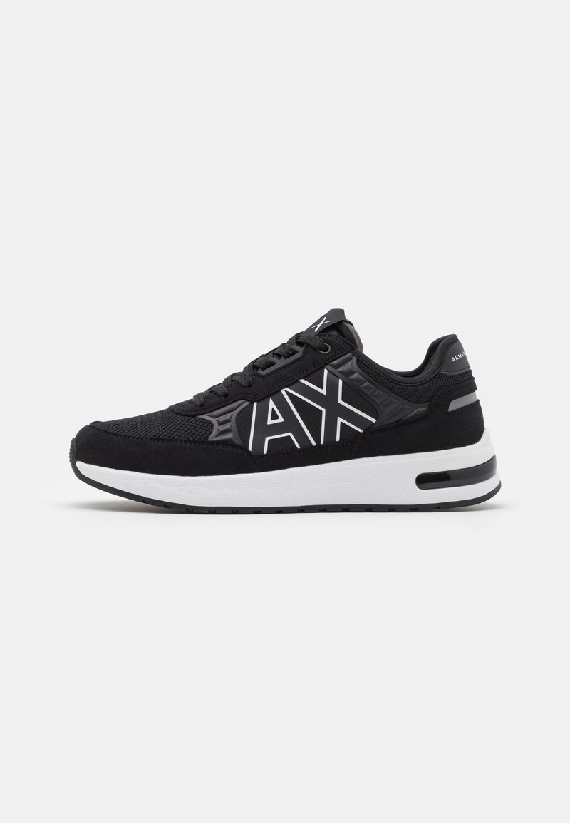 Baskets de sport noir et blanc avec logo "AX" sur le côté, tige en mesh et daim, col rembourré et semelle épaisse et coussinée.
