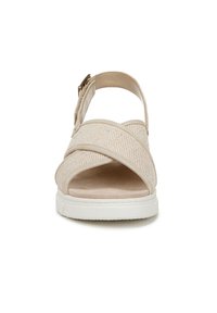 Beige sandal featuring crossed fabric straps, a cushioned footbed, and a white rubber sole. Adjustable buckle and open toe design.