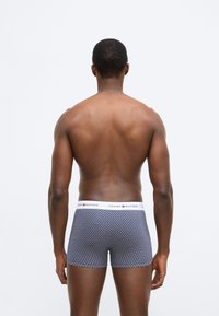 Boxershorts lavet af strækstof i mørkeblå med et geometrisk mønster. Har en kontrasterende hvid talje med logo-accenter.