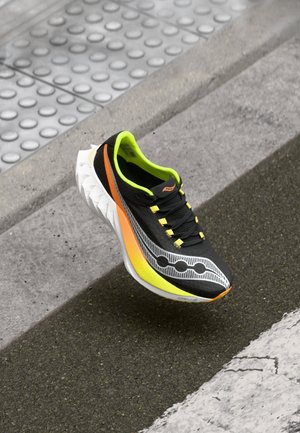 Black running shoe with yellow and orange accents. Features a textured upper, striped pattern, and a lightweight, cushioned midsole.