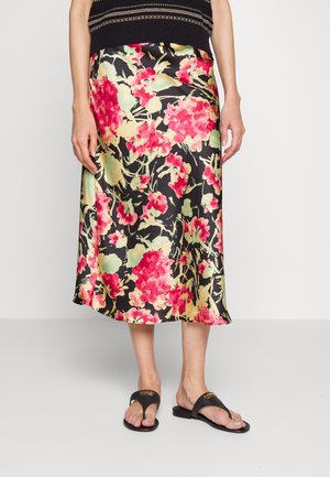 Sort midi-nederdel med pink og lysegrønt blomstermønster, båret med sorte åbne sandaler og en sort striktop.