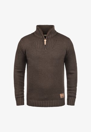 Smeđa pletena puloverica s visokim ovratnikom i polu-zatvaračem. Ima rebrast teksturu, logotip na donjoj strani i uske manžete i rub.