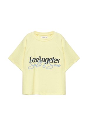 T-shirt jaune clair à manches courtes avec le texte « Los Angeles Salt & Sun » imprimé en cursive noire et grise sur le devant.
