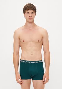 Boxer briefs para hombre en verde oscuro, fabricados con material suave, que cuentan con una cinturilla elástica negra con la marca blanca "KARL LAGERFELD".