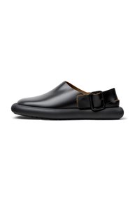 Scarpe slip-on in pelle nera con punta arrotondata, fodera in pelle marrone a contrasto e una cintura con fibbia rettangolare sul tallone.