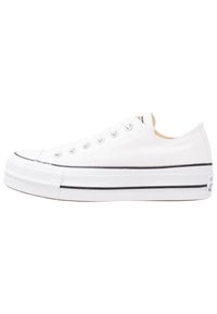 Zapatilla de lona blanca con diseño de caña baja, detalles en negro en la suela y ojales de metal redondeados para el cordón. Punta de goma texturizada.