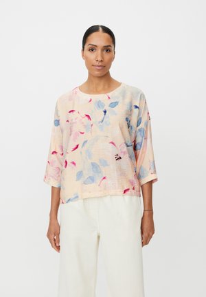 Blomstret top i pastel farver med trekvartærmer. Har rund halsudskæring og tekstureret stof med pink, blå og grønne blomsterprint.