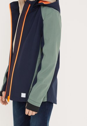 Giacca idrorepellente con corpo blu navy, maniche verdi e una cerniera con accento arancione. Presenta un cappuccio e polsini elasticizzati per una vestibilità aderente.