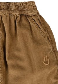 Bruine corduroybroek met elastische tailleband en zijzak, voorzien van een klein geborduurd smiley-gezichtlogo.