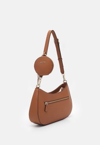 Brązowa torebka na ramię z ekoskóry o zaokrąglonym kształcie, z przednią kieszenią na zamek błyskawiczny i odczepianą okrągłą saszetką na monety, wykończona złotymi elementami.