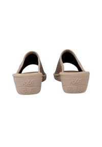 Scarpe beige slip-on con tomaia intrecciata, retro arrotondato e motivo floreale sulla suola. Caratterizzate dal logo del brand sul tallone e superficie testurizzata.