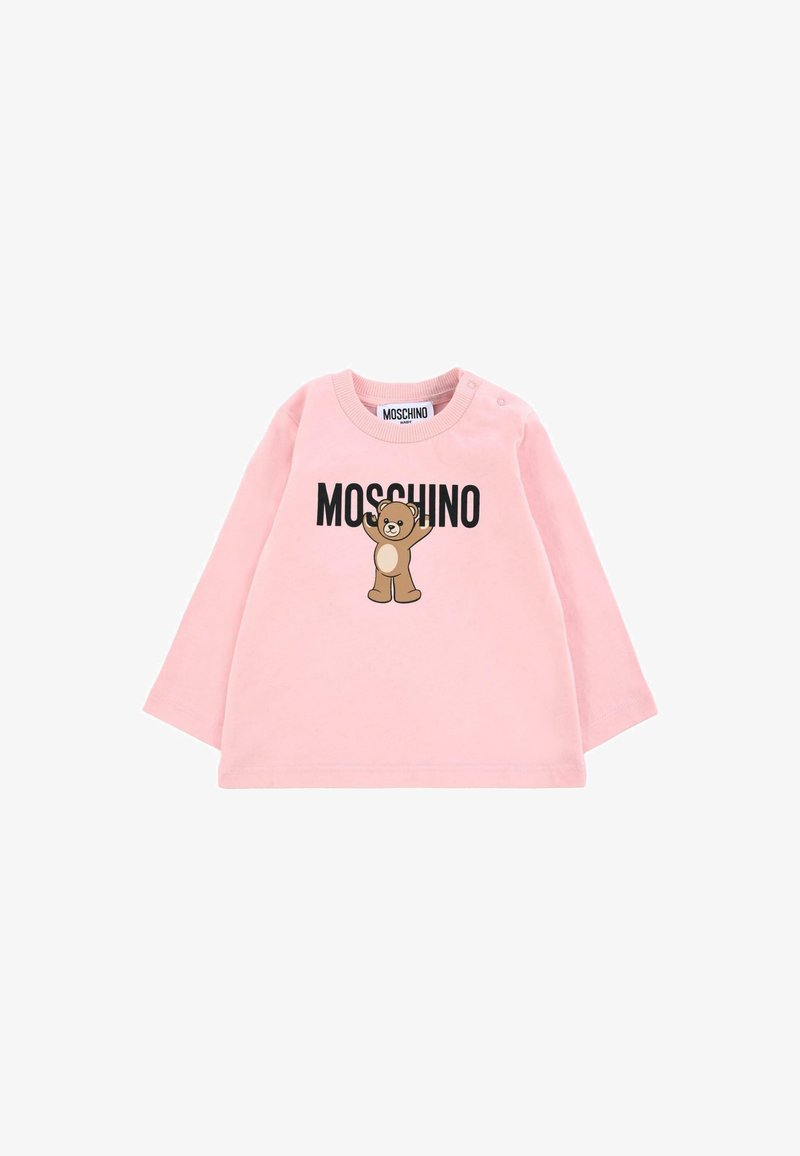 Chemise à manches longues rose en tissu doux avec un graphique d'ours brun et le texte "MOSCHINO" en noir. Fermeture à boutons-pression sur l'épaule pour un enfilage facile.