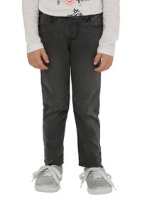 Czarne dżinsy o slim fit z przednimi kieszeniami. W zestawie z szarymi sneakerami, które mają błyszczącą teksturę i białe sznurowadła.