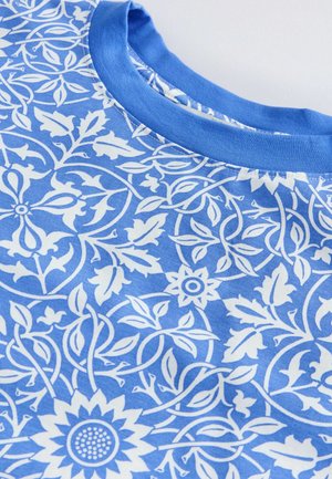 Sinine t-särk, millel on valge lille- ja viinapungade muster, ümmargune kaelus ja pehme kangasteksts.