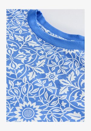 Zila t-kreklu ar baltu ziedu un vītnes rakstu, apaļo kakla izgriezumu un mīkstu auduma tekstūru.