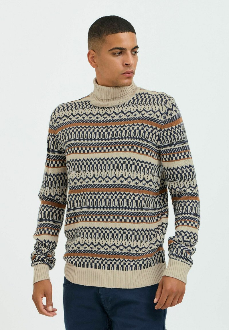 Beige coltrui met stoffen in marineblauw en oranje strepen. Geribbelde manchetten en zoom met ingewikkelde geometrische en tribale ontwerpen.