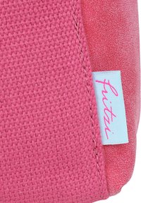 Roze geweven stof met een gestructureerd oppervlak, voorzien van een lichtblauw label met "fuitzi" in roze cursief. Naad zichtbaar aan de rechterkant.