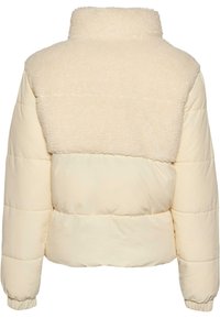 Krämfärgad puffjacka med en texturerad, fluffig ovandel och en slät underdel. Har hög krage och elastiska manschetter.