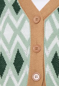 Sweter rozpinany na guziki z zielono-białym wzorem w romby, z jasnobrązową listwą na guziki i trzema brązowymi guzikami. Tkanina o fakturze z miękkim, przytulnym wykończeniem.