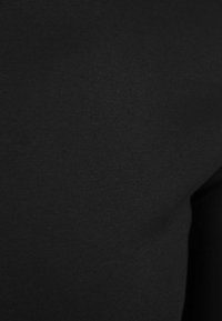 Zwart, rekbaar stof met een gladde textuur, die een effen kleur zonder patronen of zichtbare naden toont, geschikt voor verschillende kledingstukken.