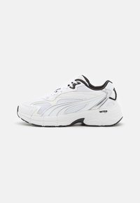 Witte sneaker met een bovenwerk van mesh en synthetisch materiaal, zwarte accenten en een dikke rubberen zool. Voorzien van gebogen lijnen en veters voor een stevige pasvorm.