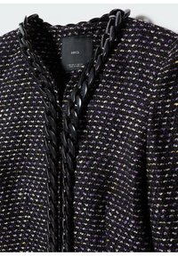 Czarna i fioletowa teksturowana kurtka z wzorem tkanym, z grubym czarnym łańcuchem przy dekolcie i metką wewnątrz.