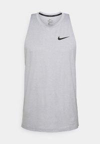 Camiseta sin mangas gris hecha de un tejido que absorbe la humedad, con un escote redondo y un pequeño logo negro de Nike en el pecho.