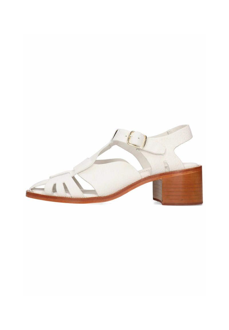 Sandalia de piel blanca con punta abierta, diseño recortado, correa ajustable en el tobillo y un bajo tacón de madera.