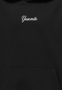 Sort hættejakke med en frontlomme og hvid, kursiv broderi af "Yosemite" på brystet. Glat stofstruktur, normal pasform.