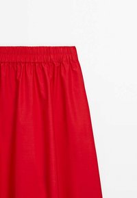 Jupe rouge à taille élastique, fabriquée en tissu lisse. Présente une silhouette fluide et une texture légère.