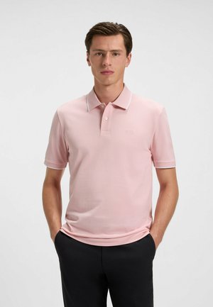 Lys pink polo skjorte med klassisk krave, korte ærmer og hvid kant. Har et diskret logo på brystet og en glat tekstur.