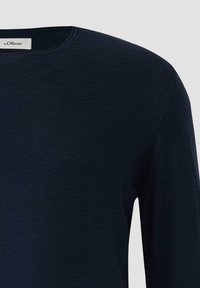 Granatowy, długi sweter z okrągłym dekoltem i długimi rękawami, z widoczną metką marki s.Oliver wewnątrz kołnierza, na jednolitym jasnym tle.