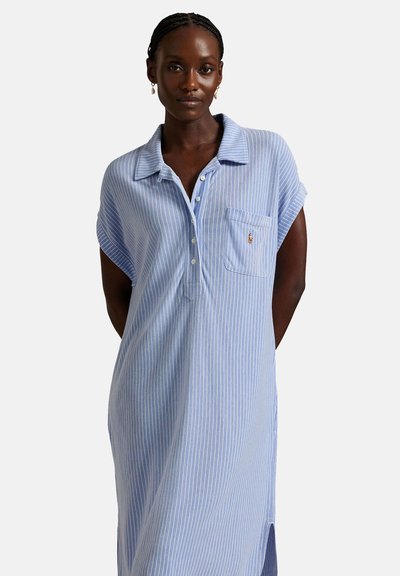 Jasnoniebieska sukienka koszulowa w paski z krótkimi rękawami, z zapięciem na guziki, kołnierzykiem oraz kieszonką na piersi z małym logo. Miękki, oddychający materiał.