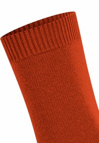 Dettaglio ravvicinato di un polsino di una calza arancione a coste che mostra la texture e le cuciture dettagliate.